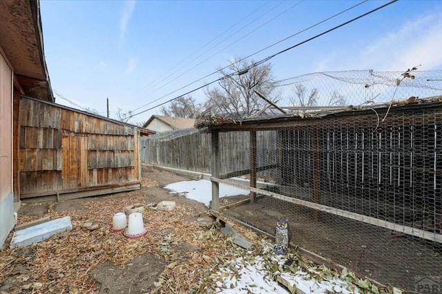 yard layered in snow with an outbuilding and exterior structure