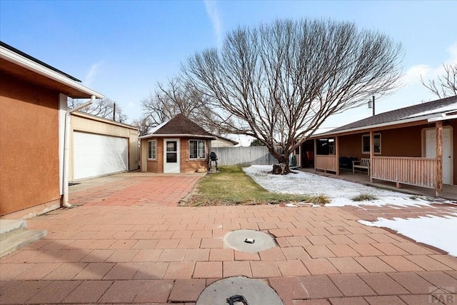 exterior space featuring a garage, an outdoor structure, and fence