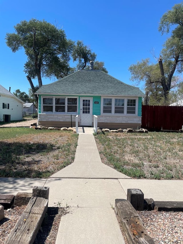 bungalow-style house featuring fence and a front lawn