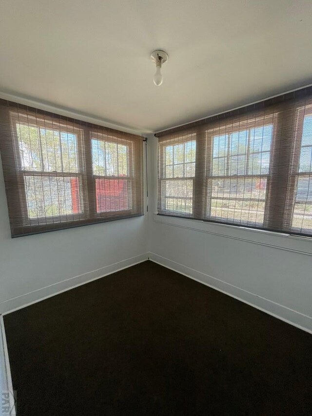 unfurnished room with a wealth of natural light and baseboards