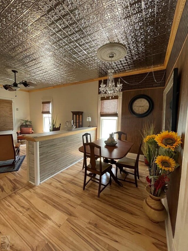 dining space featuring an ornate ceiling, a notable chandelier, ornamental molding, and wood finished floors