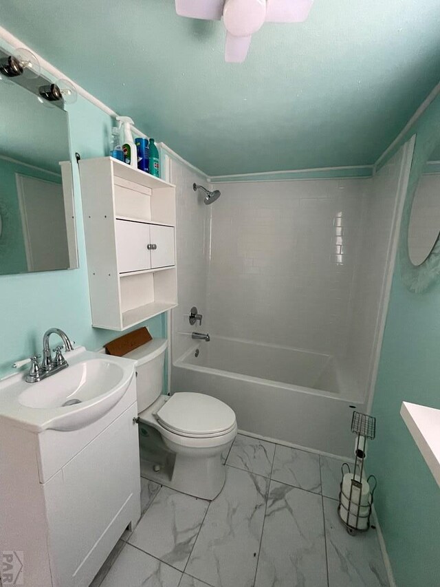 bathroom featuring marble finish floor, toilet, ceiling fan, vanity, and shower / tub combination