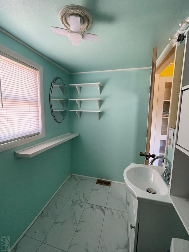 bathroom with marble finish floor, visible vents, ceiling fan, vanity, and baseboards