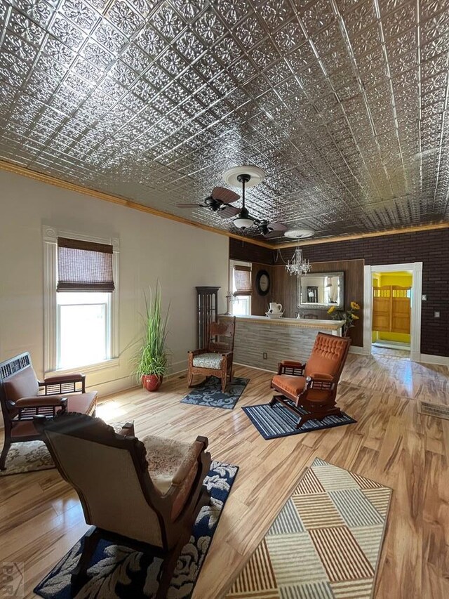 living room featuring an ornate ceiling, baseboards, crown molding, and wood finished floors