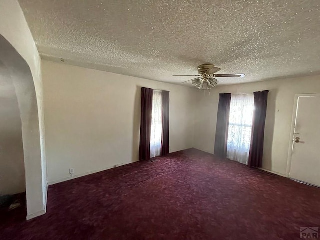 unfurnished room featuring a ceiling fan, carpet, and a textured ceiling