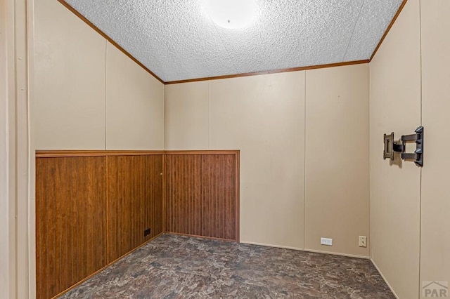 unfurnished room featuring a textured ceiling and ornamental molding