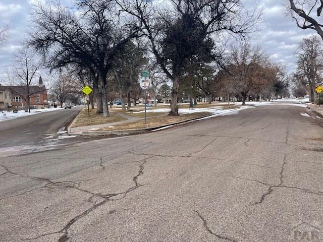 view of road with curbs, traffic signs, and sidewalks