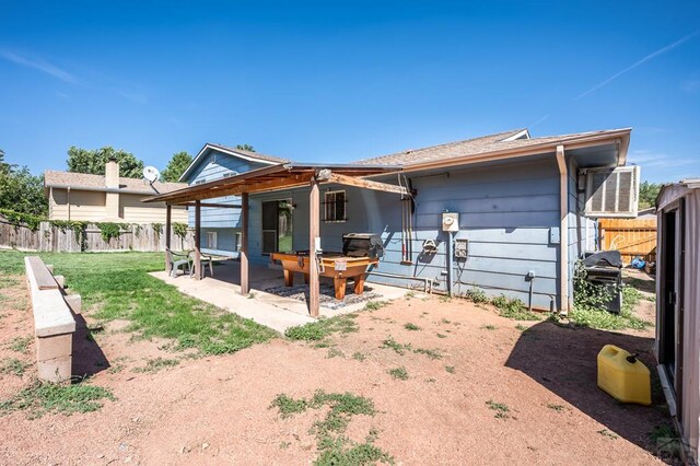 back of property with fence and a patio