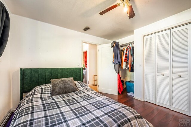 bedroom with ceiling fan, a closet, dark wood finished floors, and visible vents