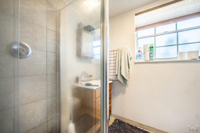 full bath featuring tiled shower and vanity