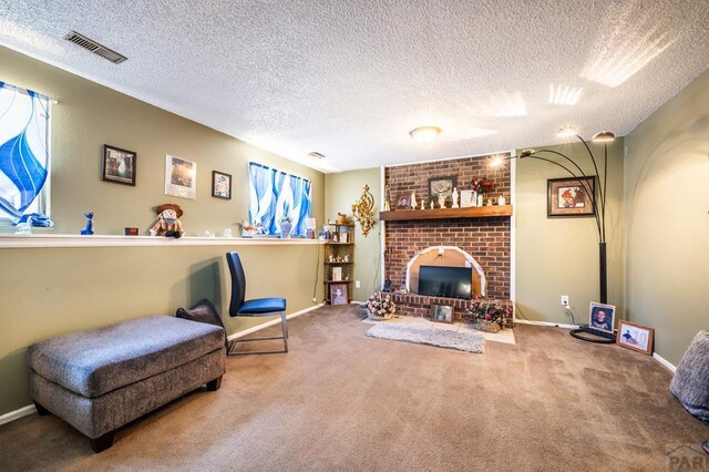 sitting room featuring visible vents, a brick fireplace, carpet flooring, a textured ceiling, and baseboards