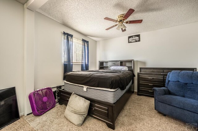 bedroom featuring light carpet, ceiling fan, and a textured ceiling