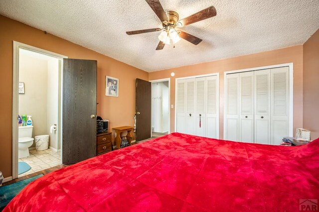 bedroom featuring a textured ceiling, two closets, a ceiling fan, and ensuite bathroom