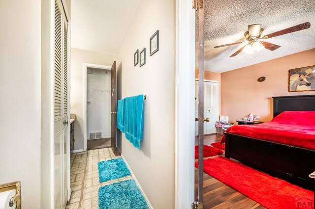 bedroom featuring visible vents, ceiling fan, and a textured ceiling