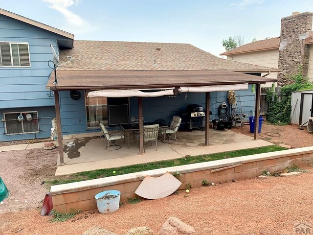 back of house with a patio area and a shingled roof