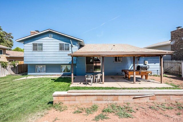 back of property with a patio area, fence, a chimney, and a lawn