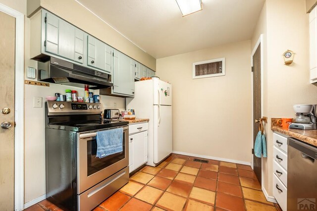 kitchen with stainless steel appliances, light countertops, under cabinet range hood, and baseboards