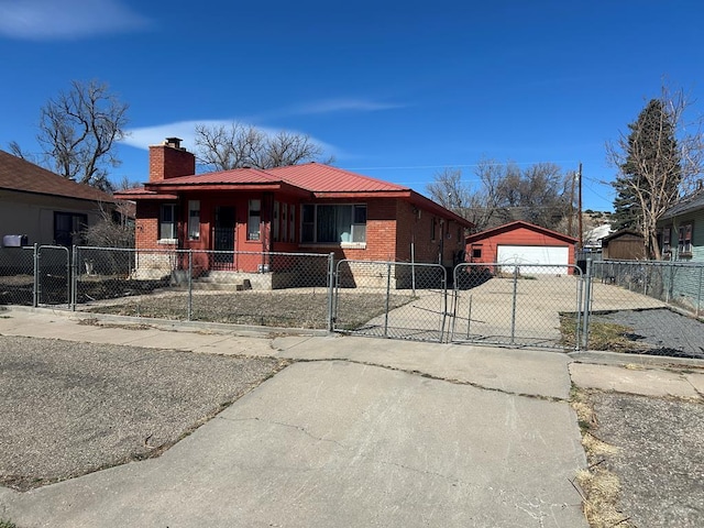 view of front facade featuring metal roof, a chimney, a garage, concrete driveway, and a fenced front yard