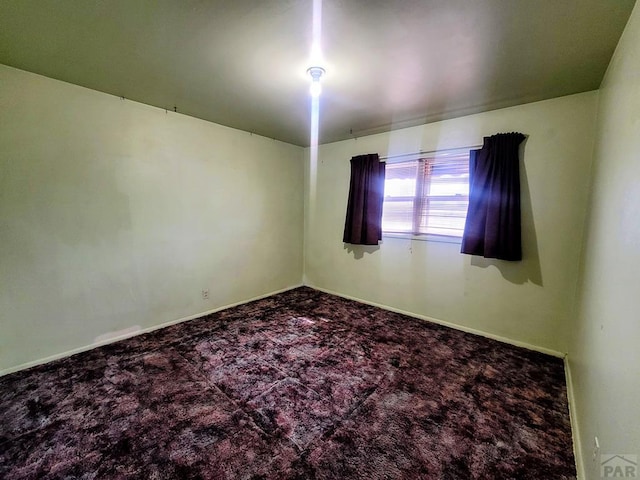 carpeted empty room with baseboards