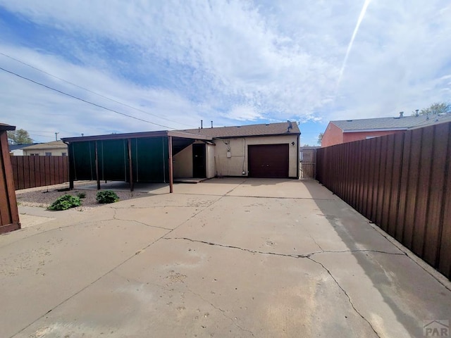 exterior space featuring fence, driveway, and a garage