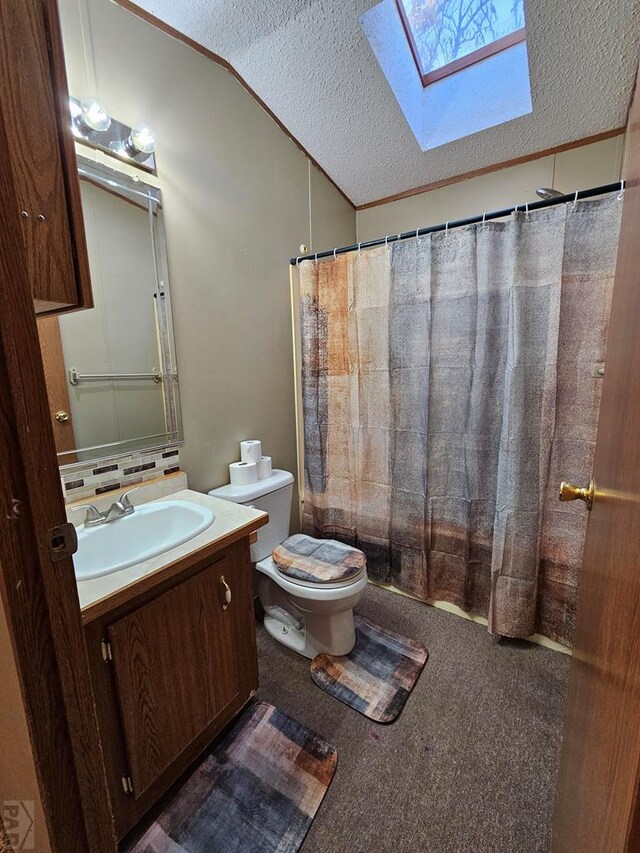 bathroom featuring a textured ceiling, lofted ceiling with skylight, vanity, and toilet