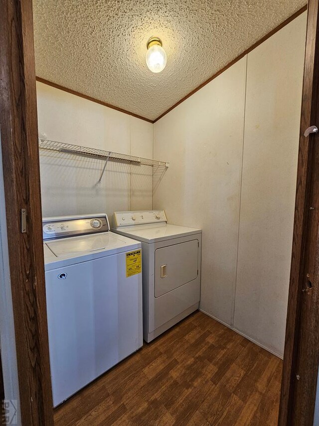 laundry room with a textured ceiling, laundry area, washer and dryer, ornamental molding, and dark wood finished floors