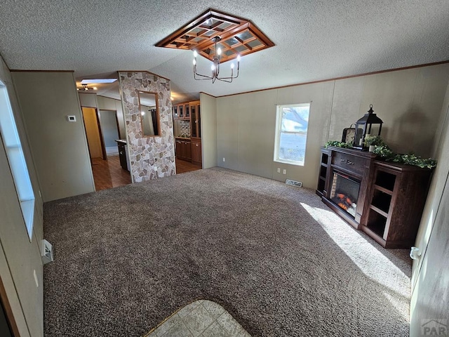 living room featuring carpet floors, a glass covered fireplace, vaulted ceiling, and a textured ceiling