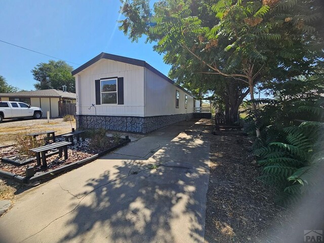 view of side of property featuring concrete driveway