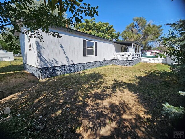 exterior space with fence and a lawn