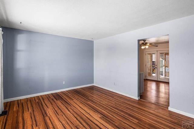 unfurnished room with dark wood-style floors, baseboards, a ceiling fan, and french doors