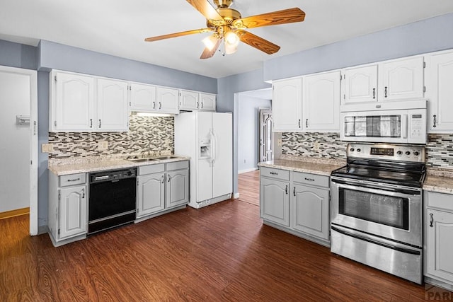 kitchen featuring dark wood-style floors, light countertops, white cabinetry, a sink, and white appliances