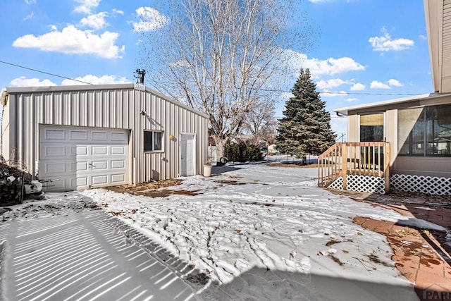 snow covered garage featuring a garage