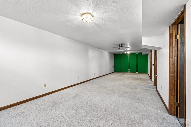 carpeted empty room with a ceiling fan, a textured ceiling, and baseboards