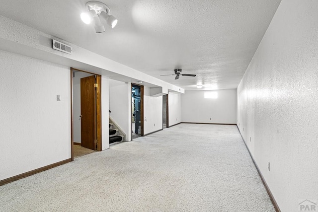 unfurnished room featuring a textured ceiling, a textured wall, stairs, and visible vents