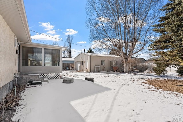 yard covered in snow with a detached garage and fence