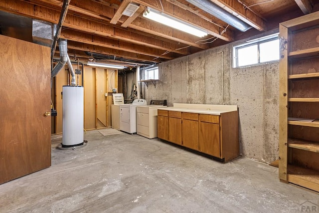 basement featuring plenty of natural light, gas water heater, and washer and dryer