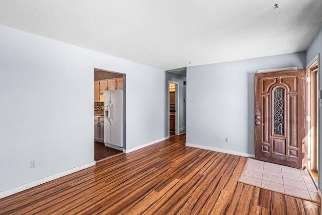 spare room featuring baseboards and light wood-style floors