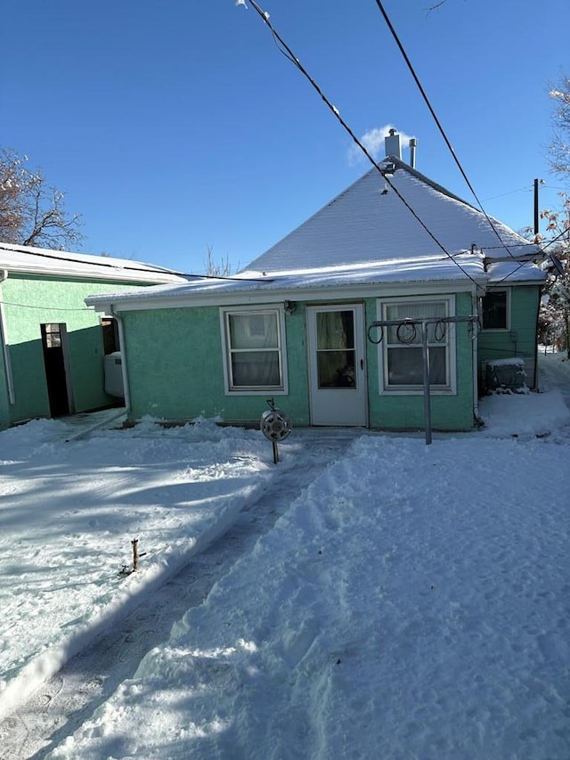 view of snow covered back of property