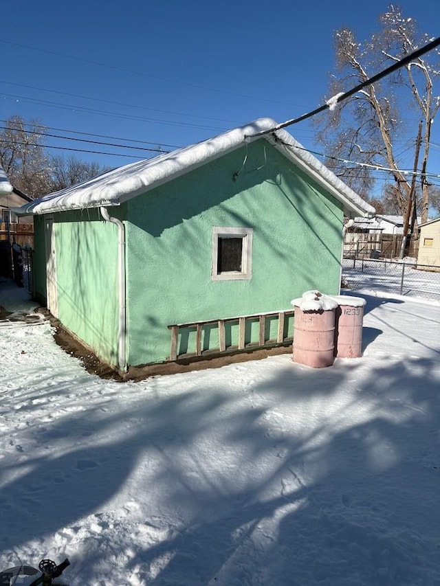 view of snowy exterior with stucco siding