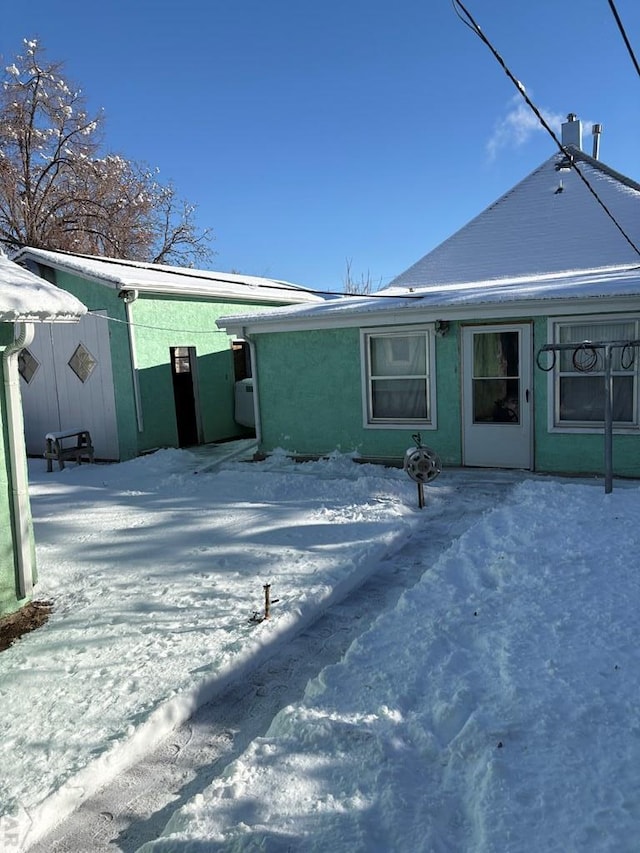 view of snow covered rear of property