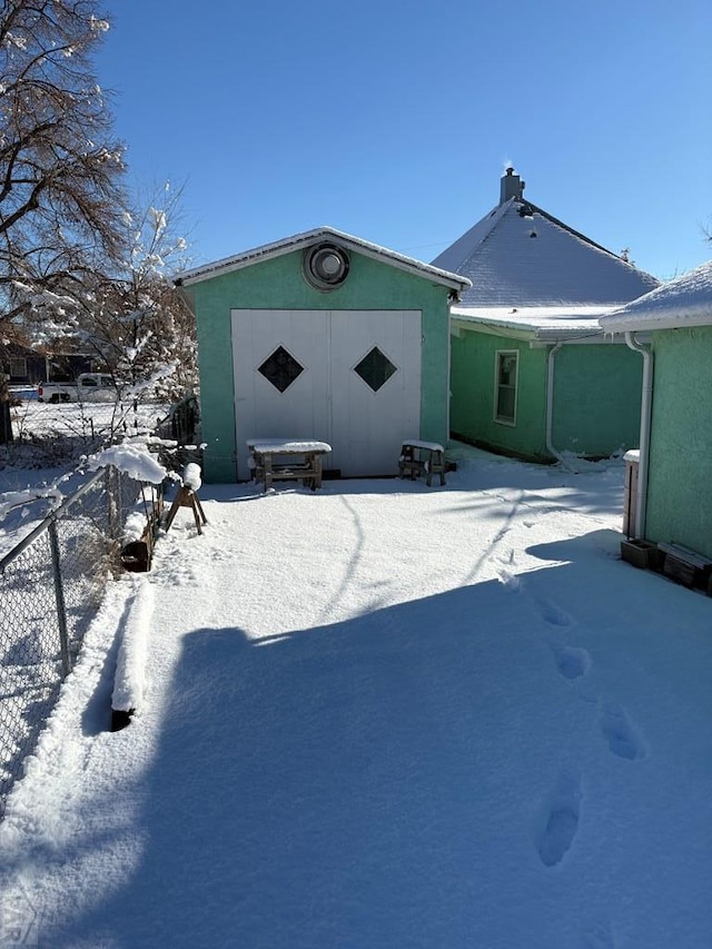 view of snow covered back of property