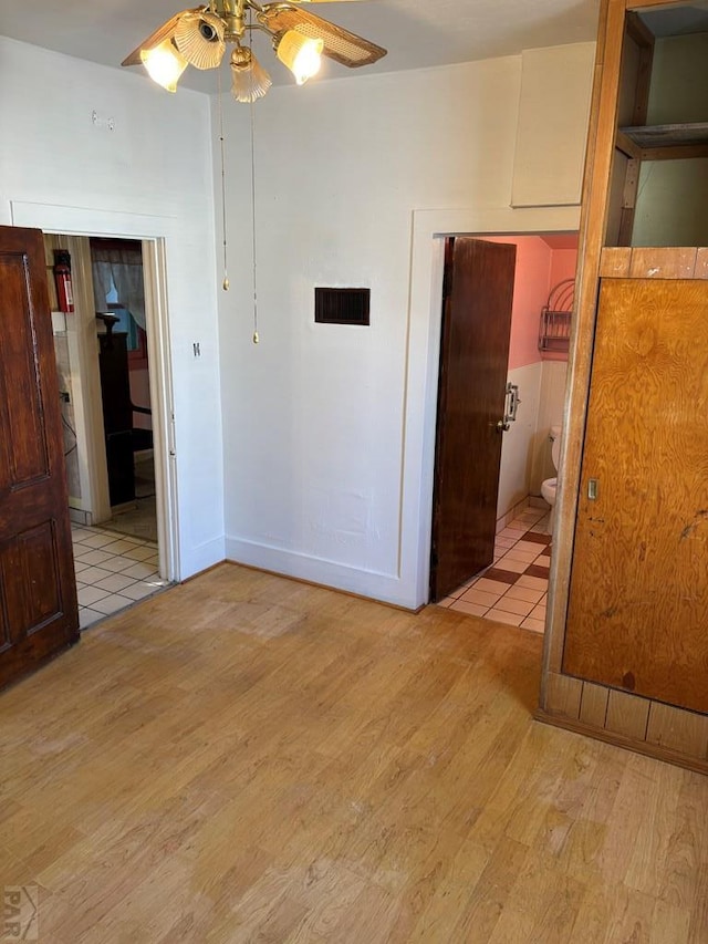 spare room with light wood-style floors, visible vents, and a ceiling fan