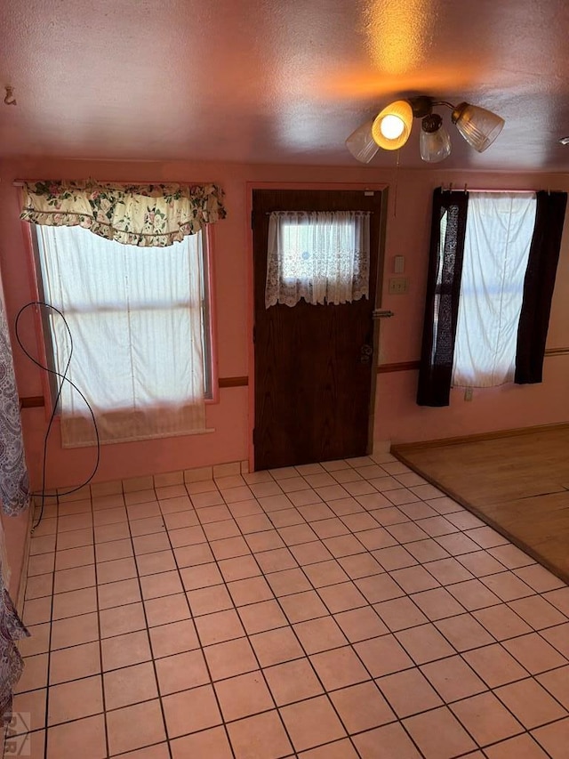 entryway featuring light tile patterned floors and a textured ceiling