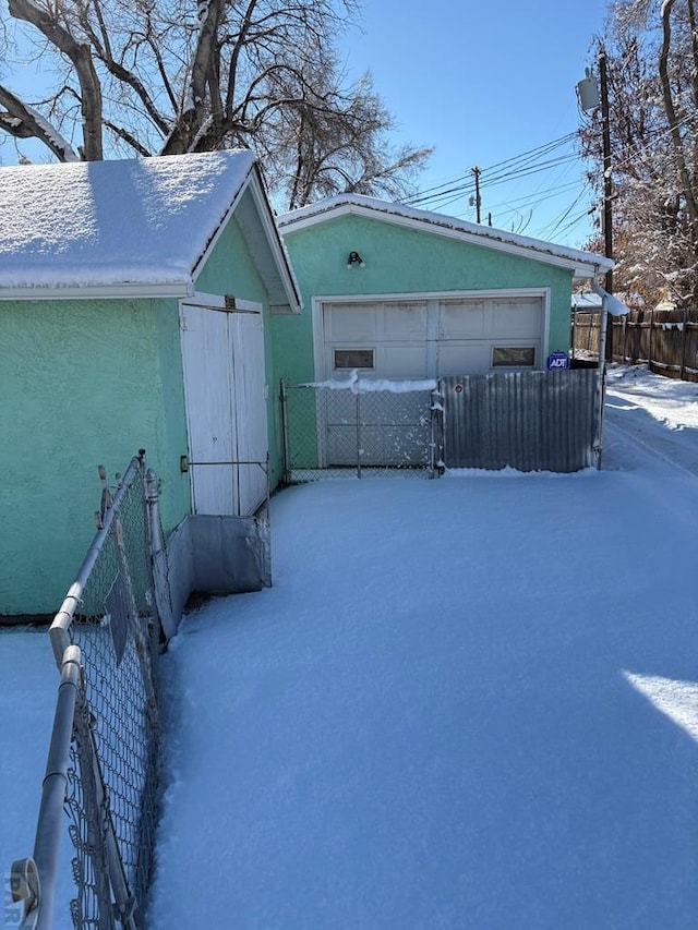 snow covered structure featuring a fenced front yard