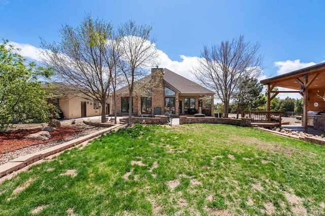 view of yard featuring a deck, ceiling fan, and a patio
