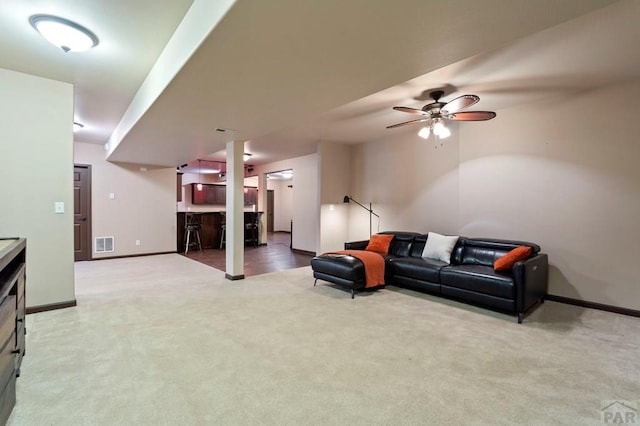 living room featuring baseboards, visible vents, ceiling fan, and carpet flooring