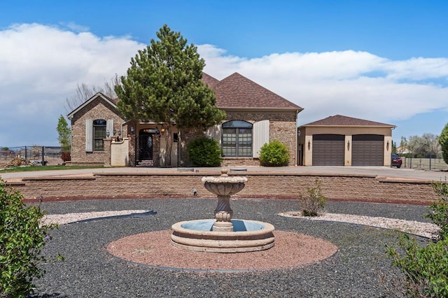view of front of house featuring brick siding, a shingled roof, an attached garage, and fence