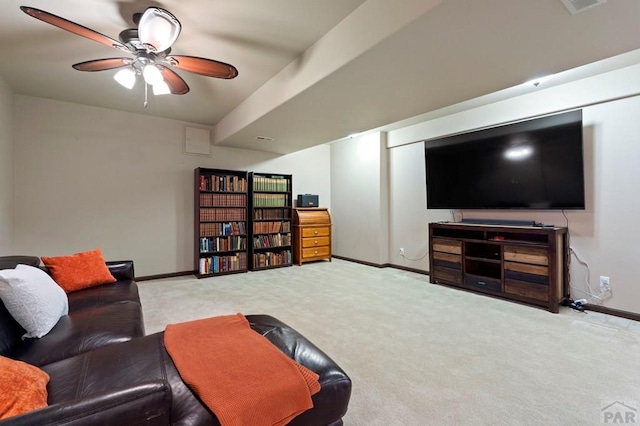 carpeted living area with a ceiling fan and baseboards