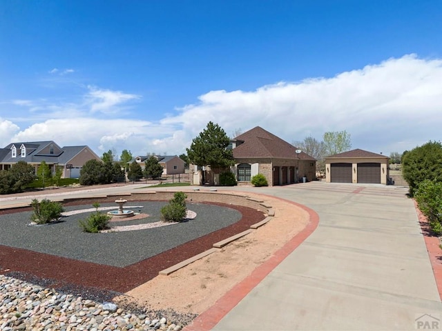 view of front of property with a garage, a residential view, and curved driveway