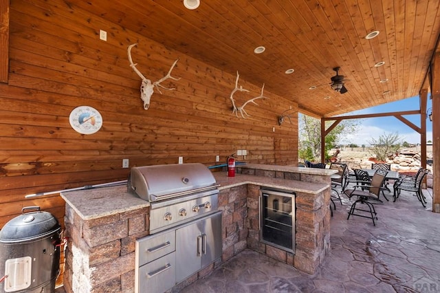 view of patio / terrace with a ceiling fan, area for grilling, outdoor wet bar, and a grill